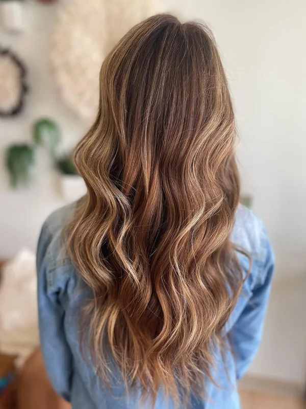 Long brunette waves with soft, sunlit dimension, blended by Amy Kurtz